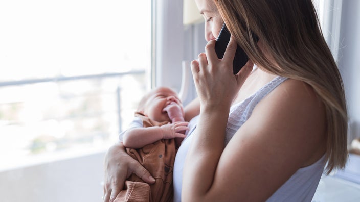 A parent holding their baby and calling a doctor.
