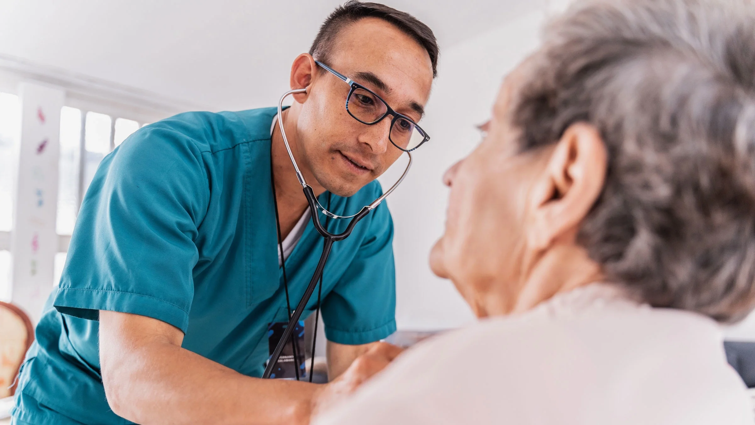 A doctor listening to a patient's heartbeat.