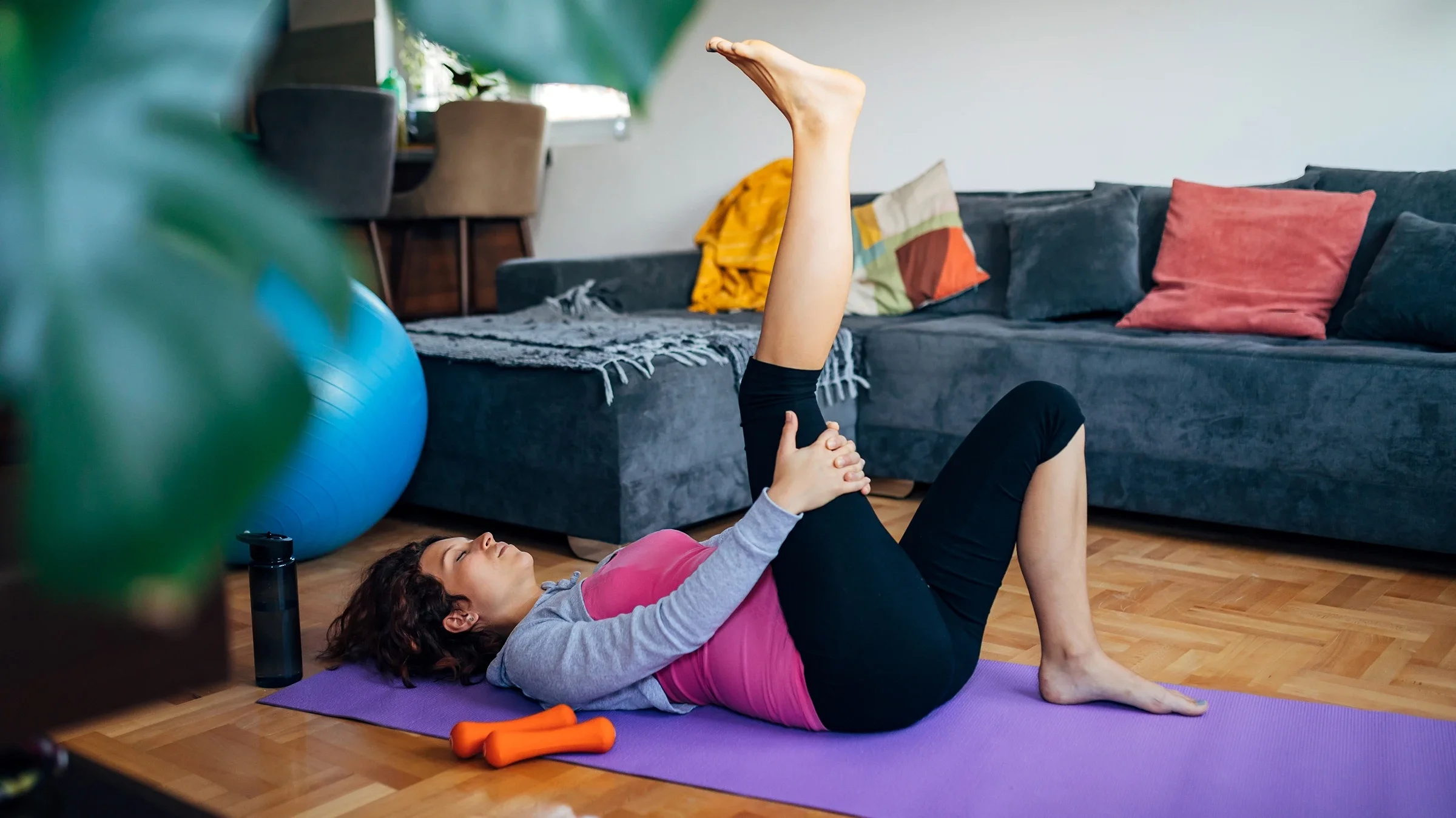 Woman doing knee-to-chest sciatic nerve floss.