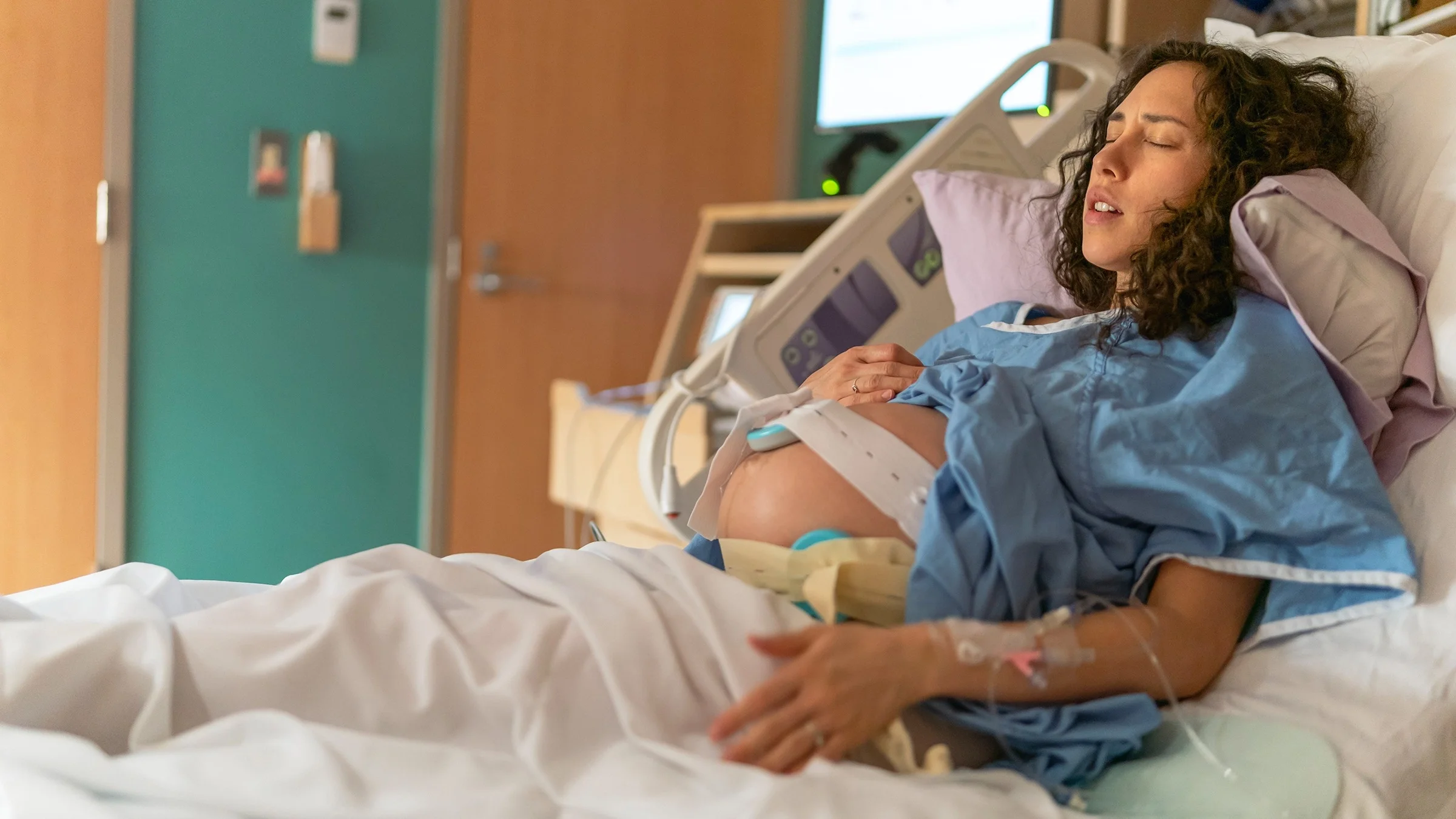 Woman in hospital bed having contractions while in labor.