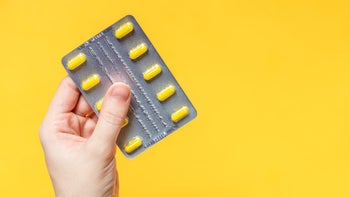 Gabapentin: hand holding blister pack yellow background1436562348