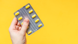 A hand is holding a blister pack of yellow pills against a yellow background.
Iana Miroshnichenko/iStock via Getty Image
