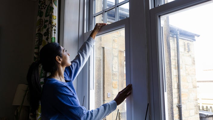 Woman closing a window.