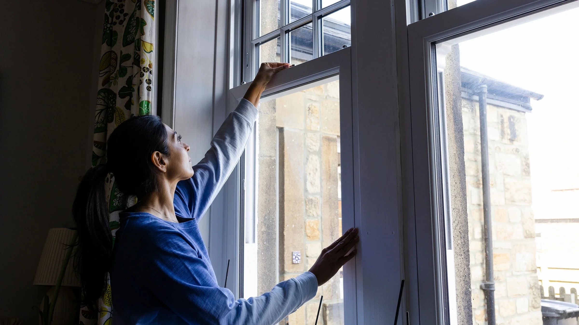 Woman closing a window.