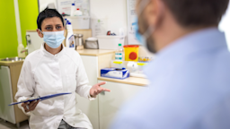 A masked doctor talking to a patient.
miodrag ignjatovic/E+ via Getty Images 