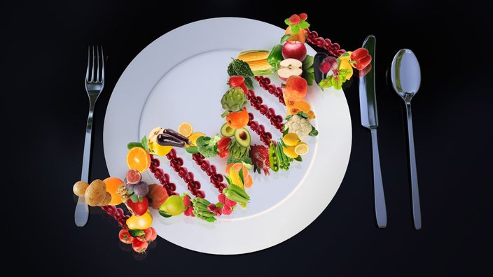 A place setting with a DNA helix made of fruits and vegetables on a plate.