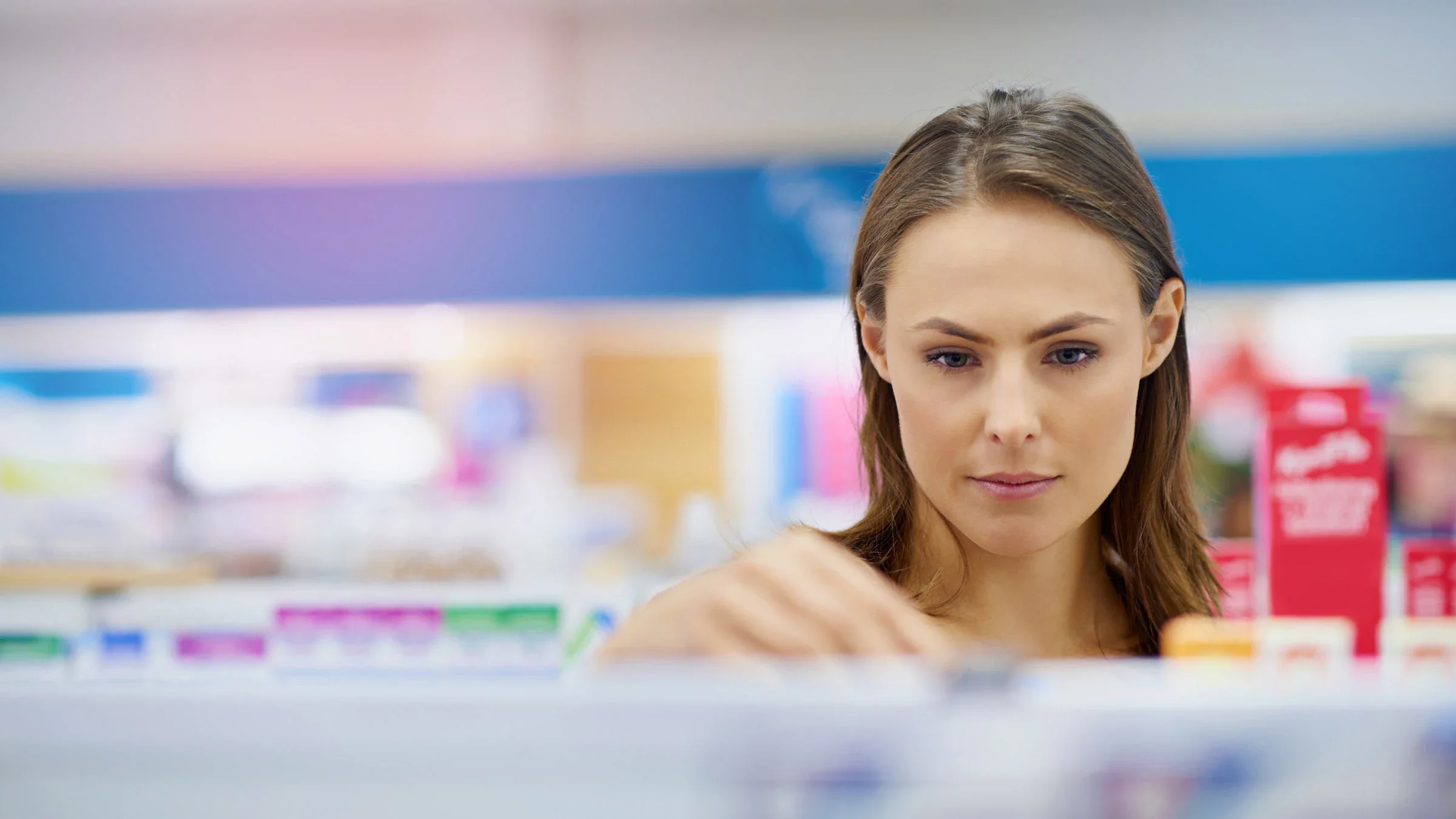 A customer in a pharmacy aisle reaching for an OTC medication.
Yuri_Arcurs/iStock via Getty Images Plus