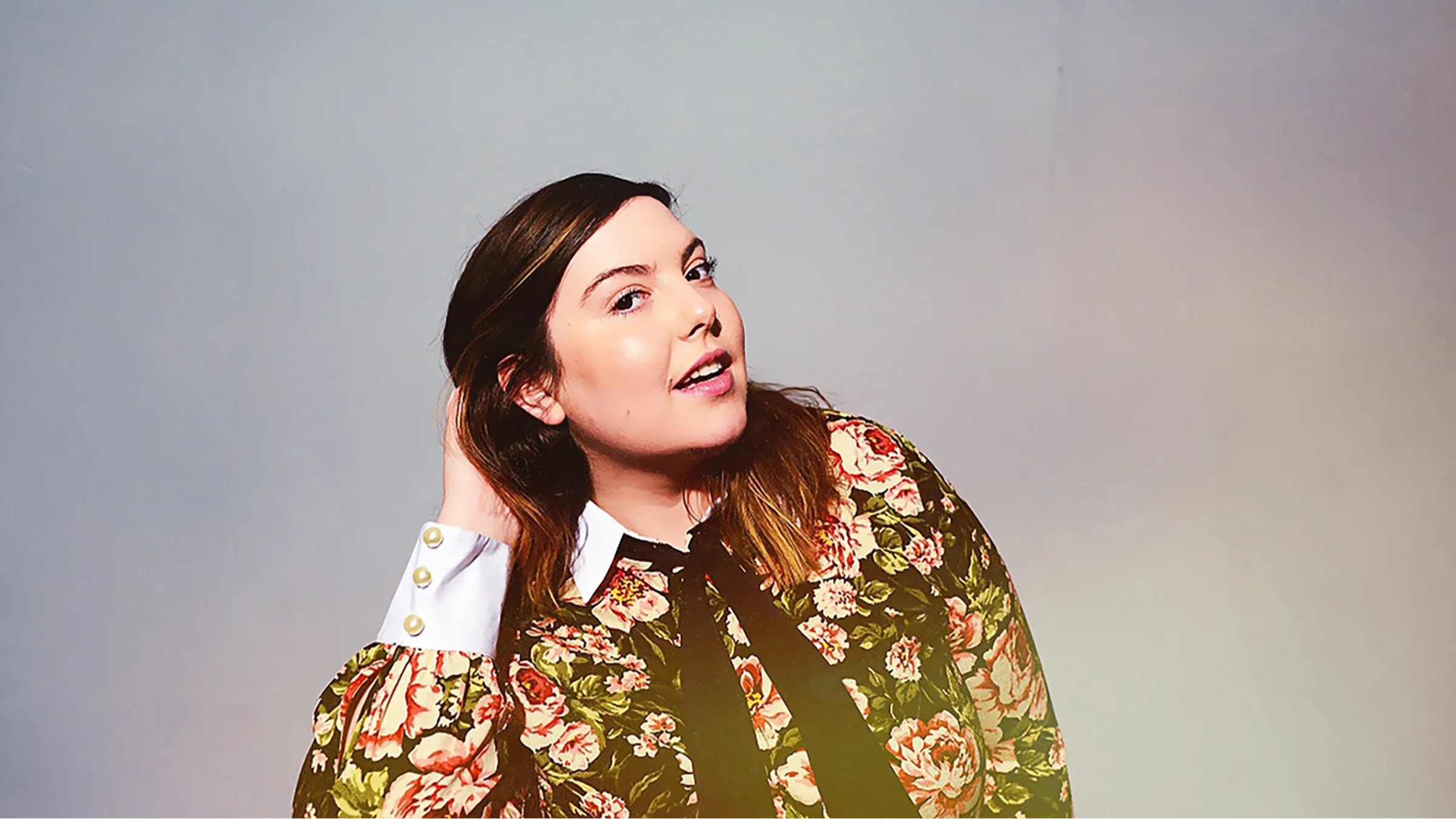 Portrait of singer-songwriter Mary Lambert in a flowered shirt.