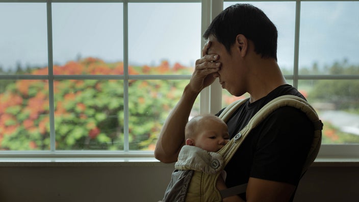 A stressed out dad with baby in a sling.