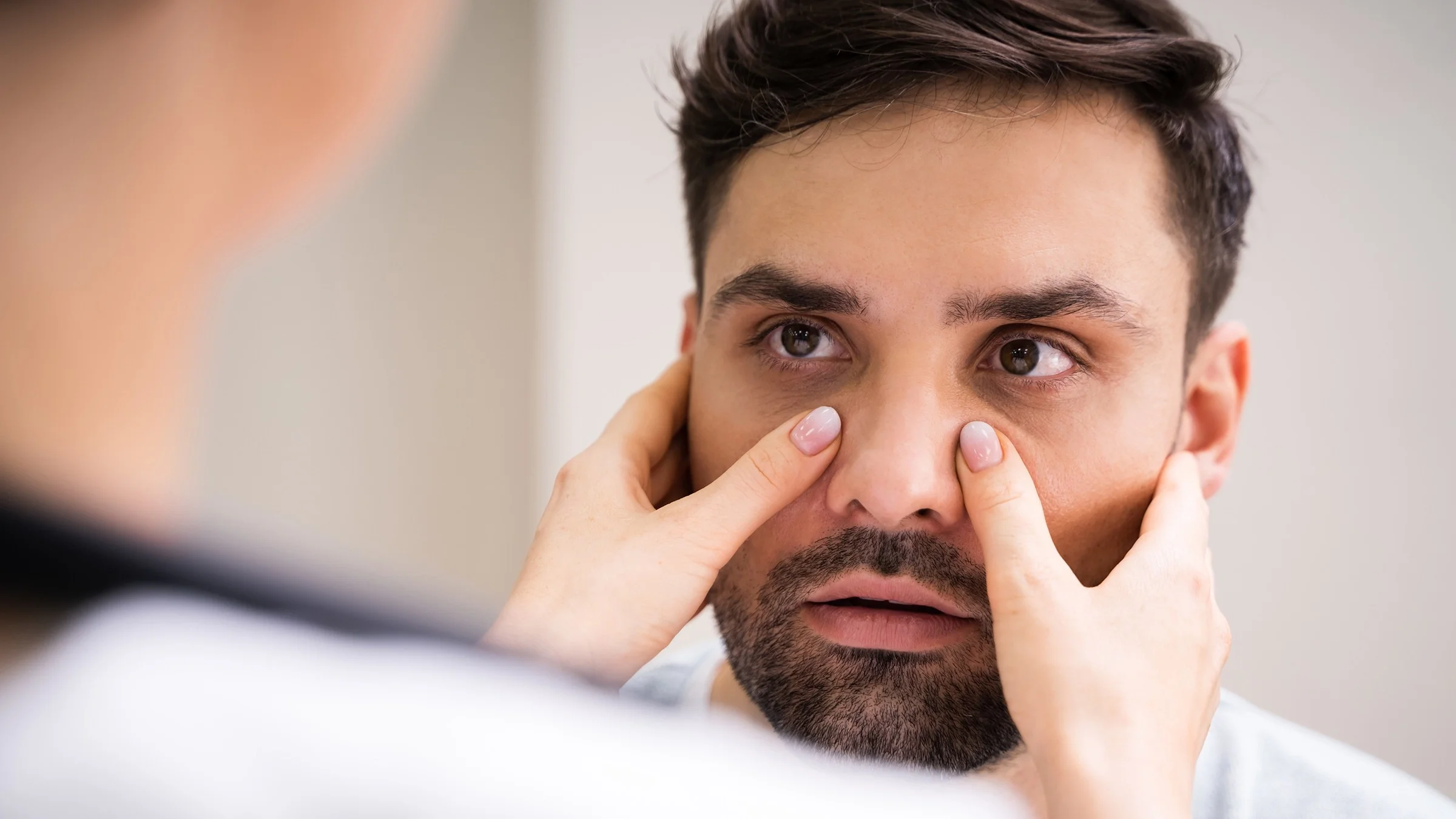 Close-up portrait of a man having his sinuses examined.