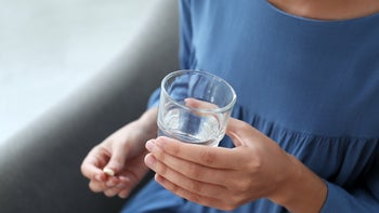 Health: Xeljanz: closeup woman taking pill with water 1356128998