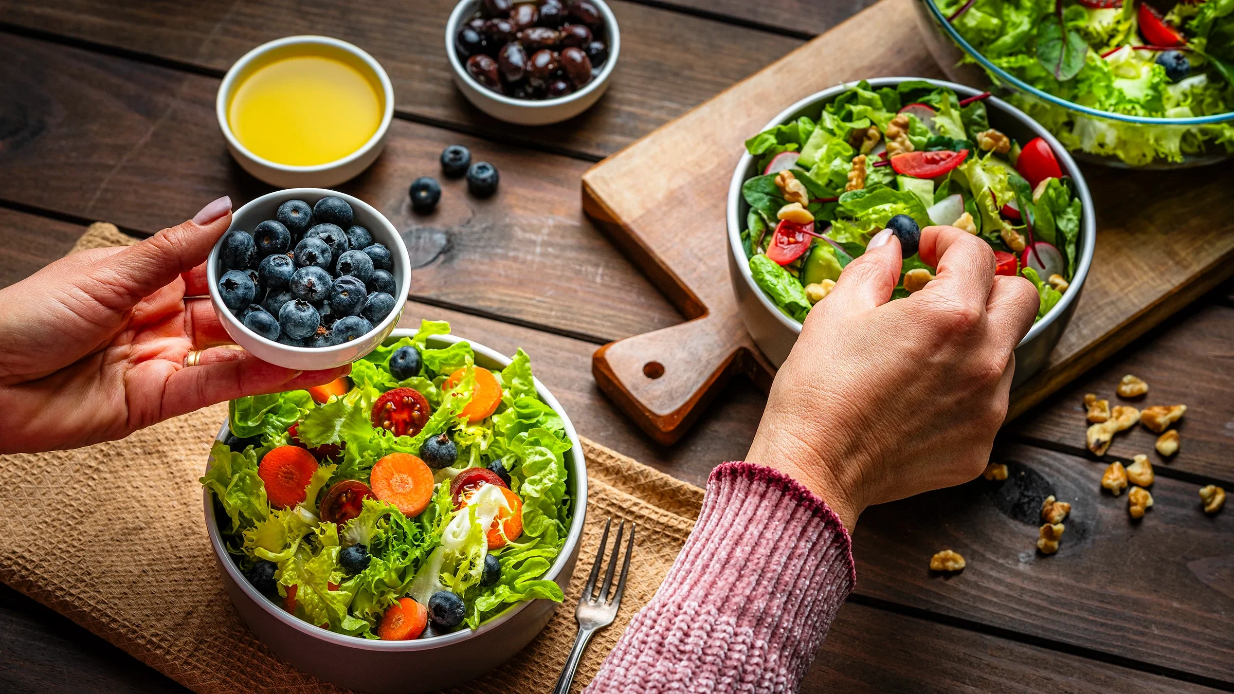 Assembling a salad with blueberries.