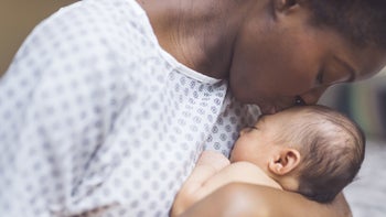 Health: Pregnancy: mother kissing newborn baby GettyImages-952682282