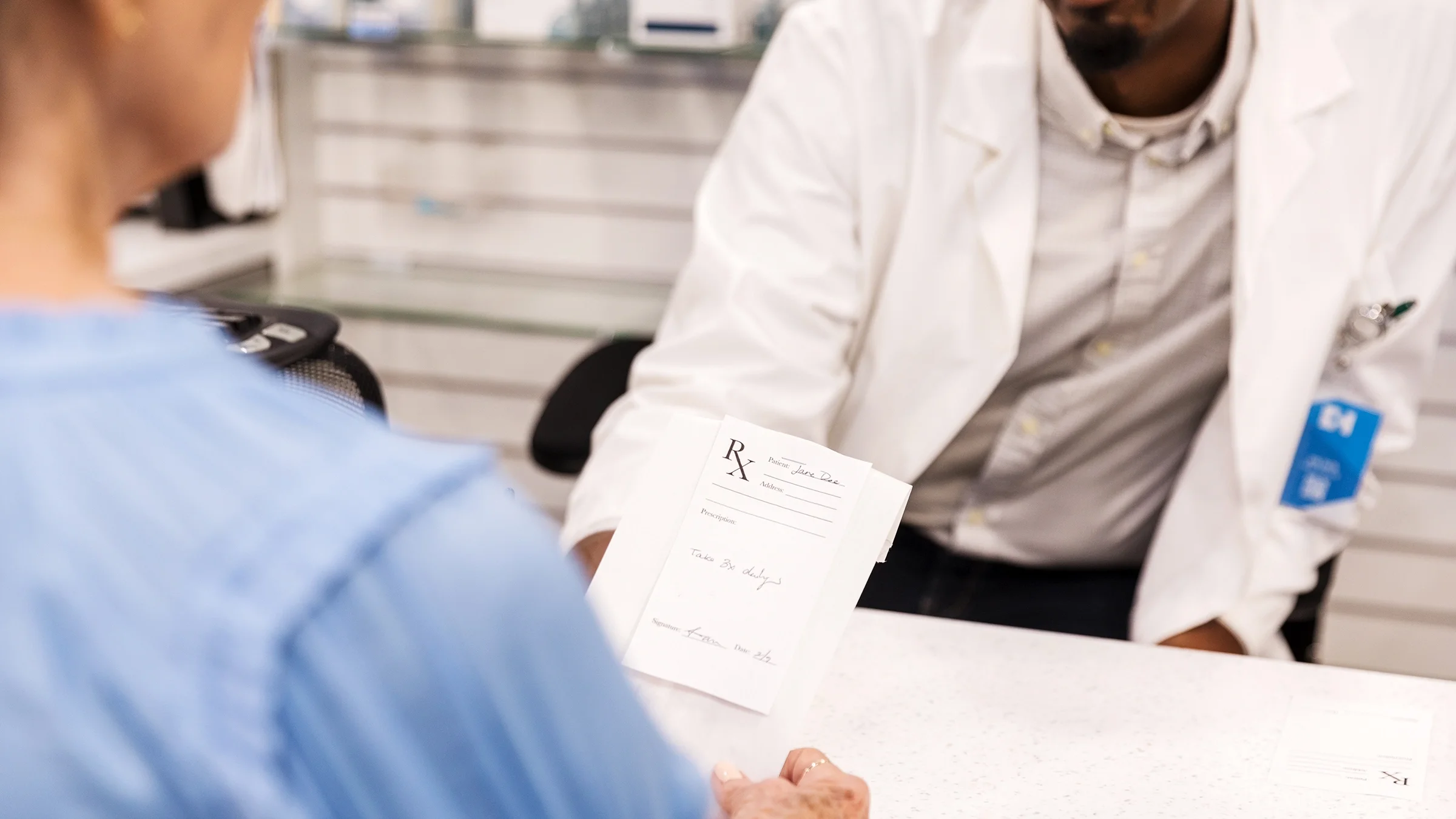 A customer asks a pharmacist about her prescription.