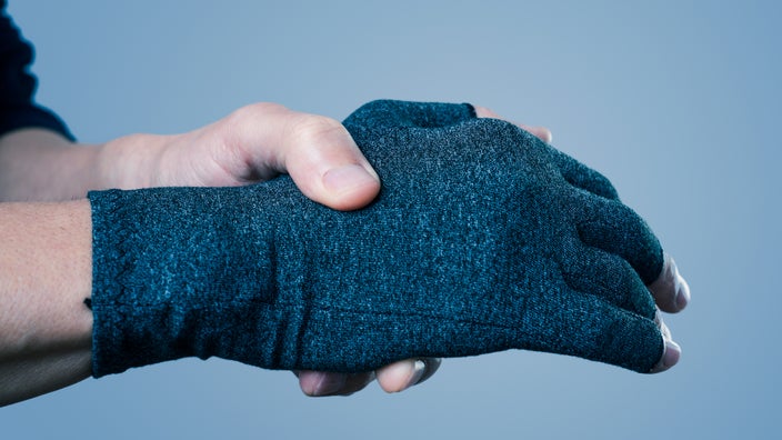 Close-up hand wearing a compression glove.
