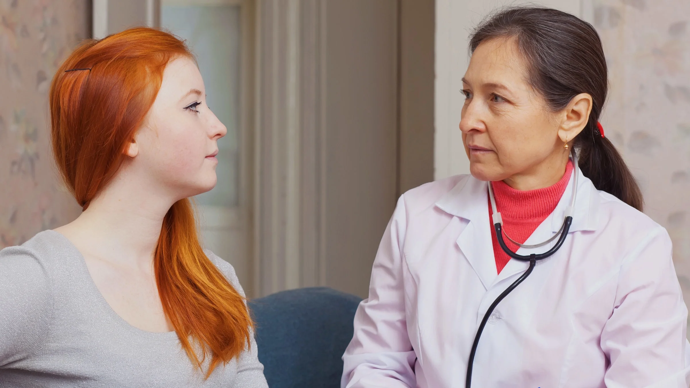 A doctor talking to a teenager.