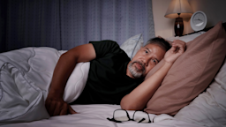 A man lies in bed, struggling to fall asleep due to a bout of insomnia.
nong2/iStock via Getty Images Plus