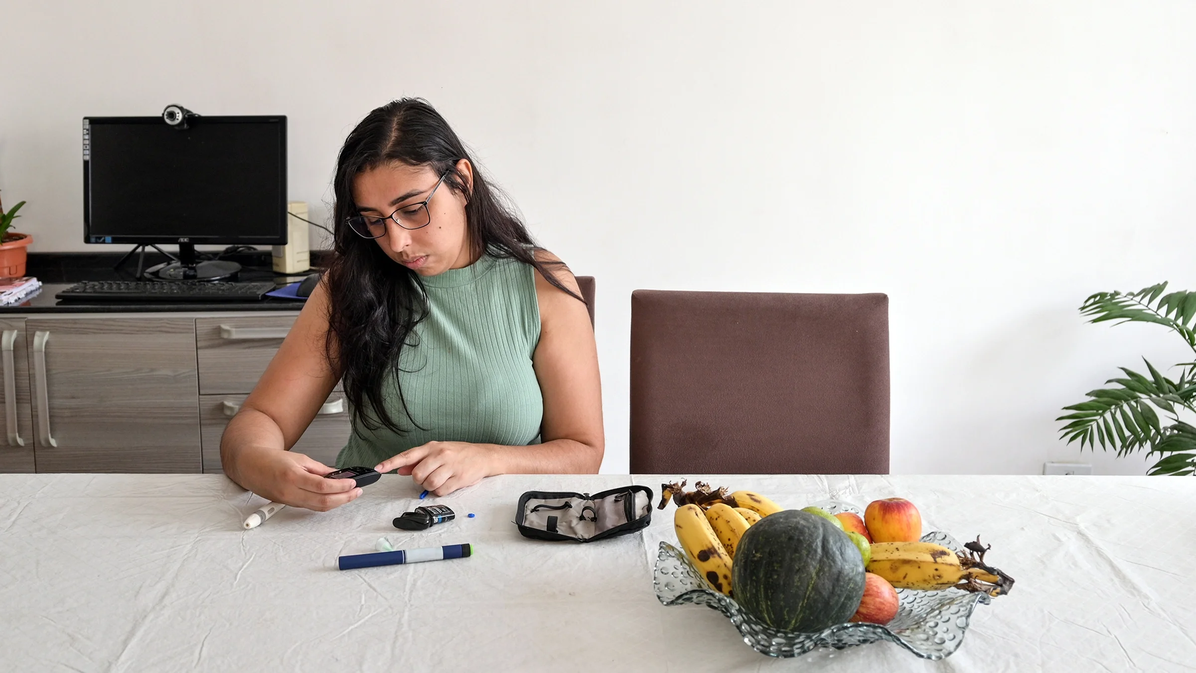 A woman checks her blood sugar levels before preparing to take her insulin shot.