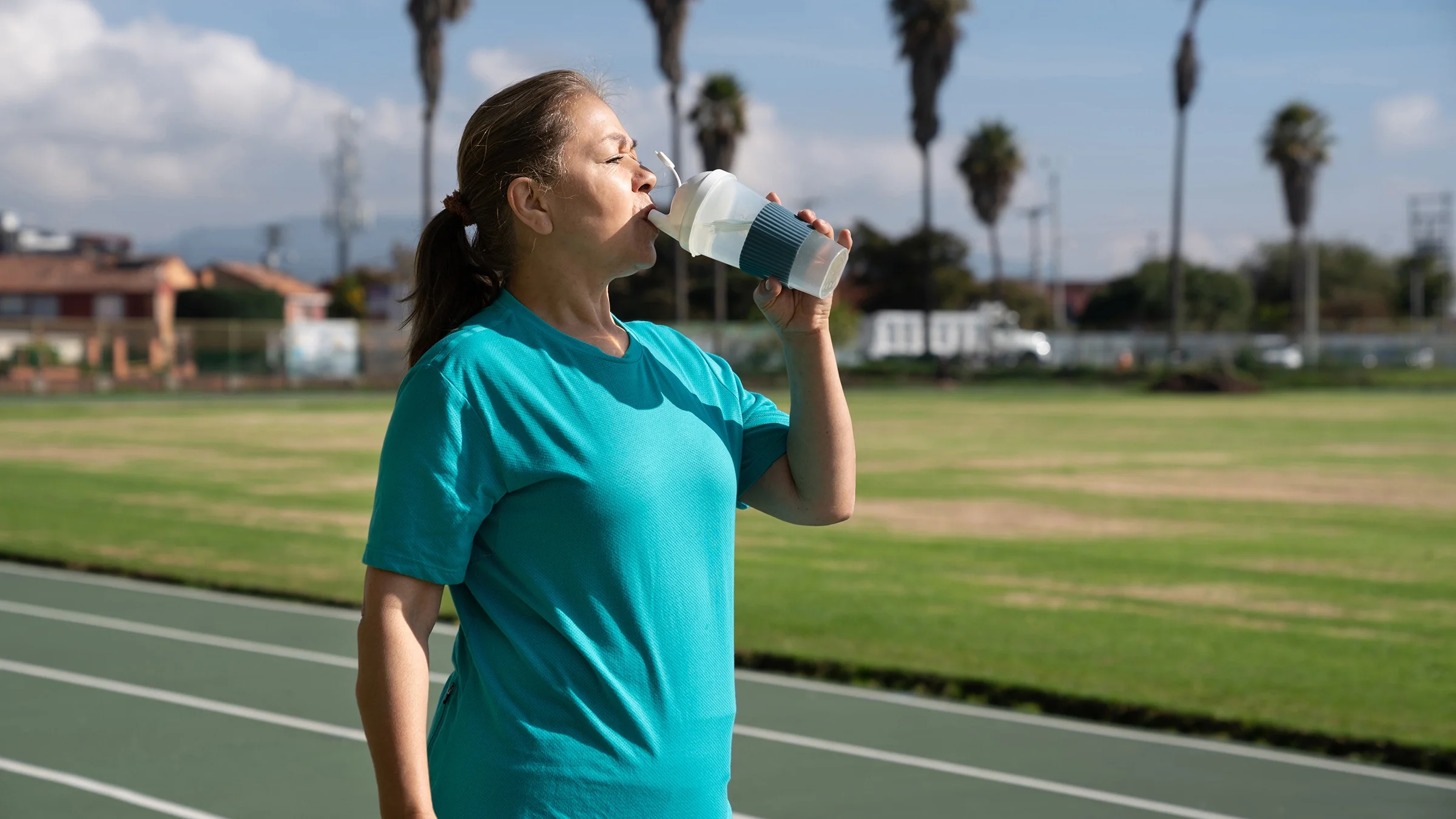 Woman hydrating while walking at the track