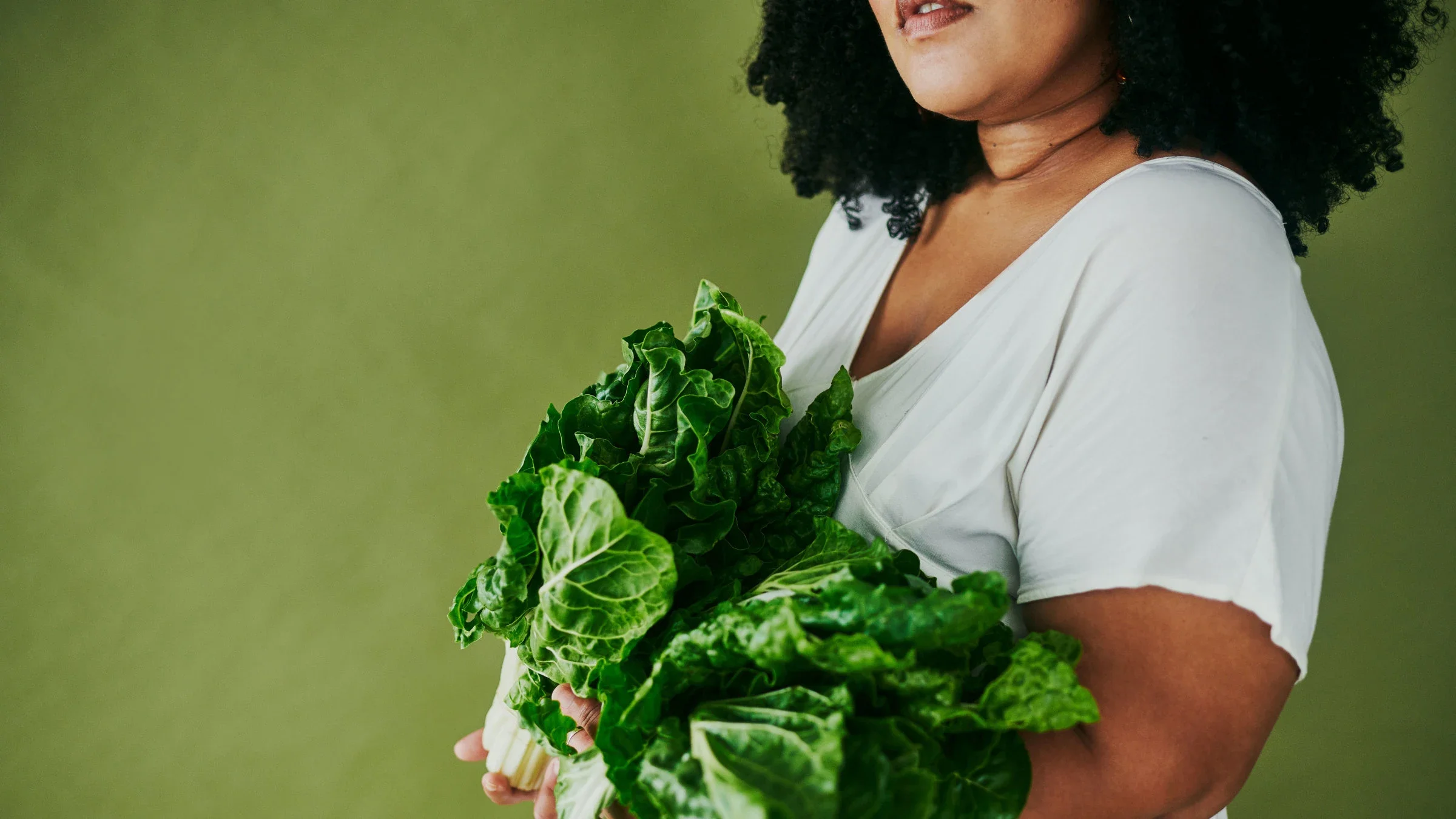 Woman holding leafy greens.
Delmaine Donson/iStock via Getty Images