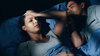 Health: Mental health: woman overthinking and lying in bed 1073141256