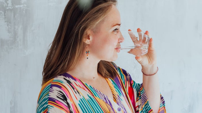A plus-size person drinking water.