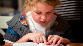 neurological: child reading with finger on page 181897692