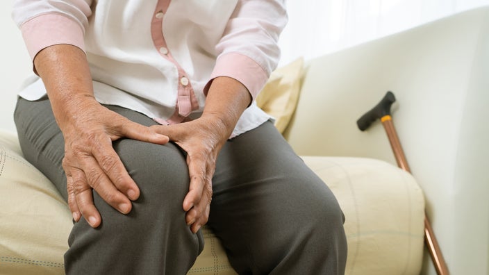 Cropped shot of an older adult holding their knee in pain.
