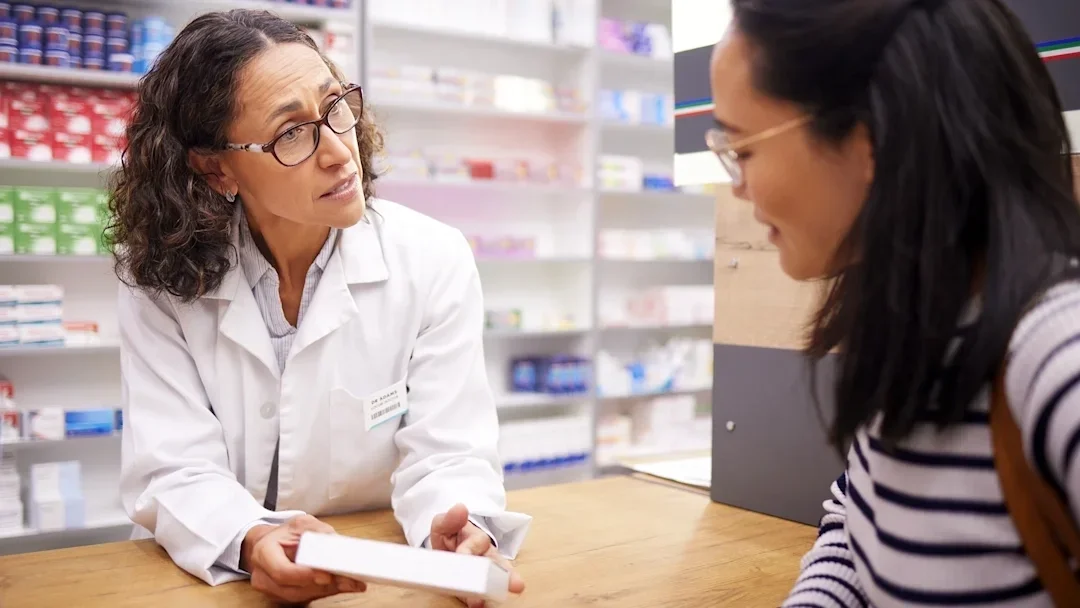 A pharmacist speaks to a customer.