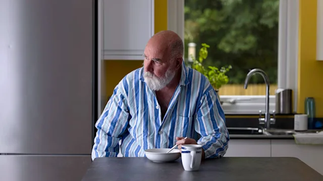 Food Poisoning: tired man eating in kitchen 1331676150