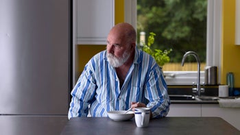Food Poisoning: tired man eating in kitchen 1331676150