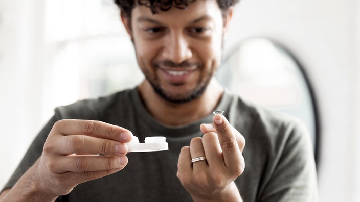 A man prepares to put in his contact lenses.