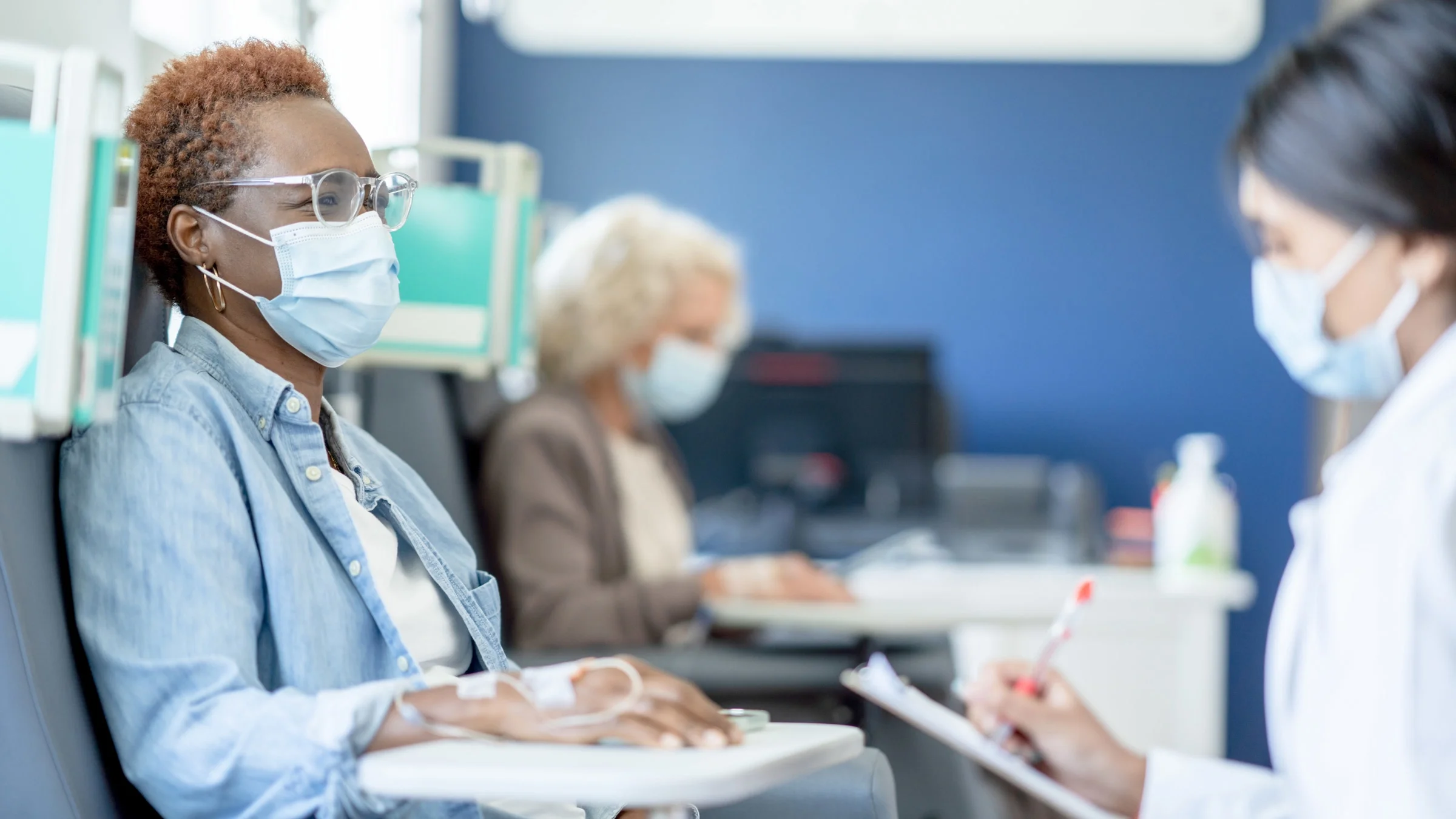 A doctor talking to patient and taking notes.