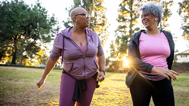 two women working out together in the park-1300215871
