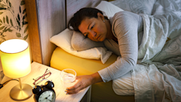 A woman reaches for a glass of water from the night table.
fcafotodigital/iStock via Getty Images Plus 
