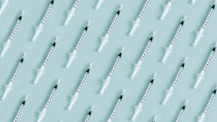 Pattern of syringes on a light blue background.