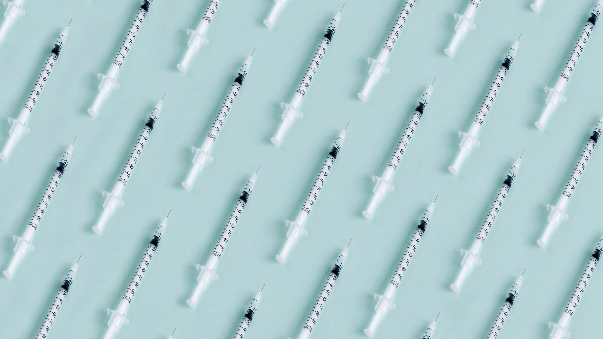 Pattern of syringes on a light blue background.