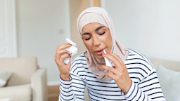 A woman uses nasal spray at home
stefanamer/iStock via Getty Images Plus