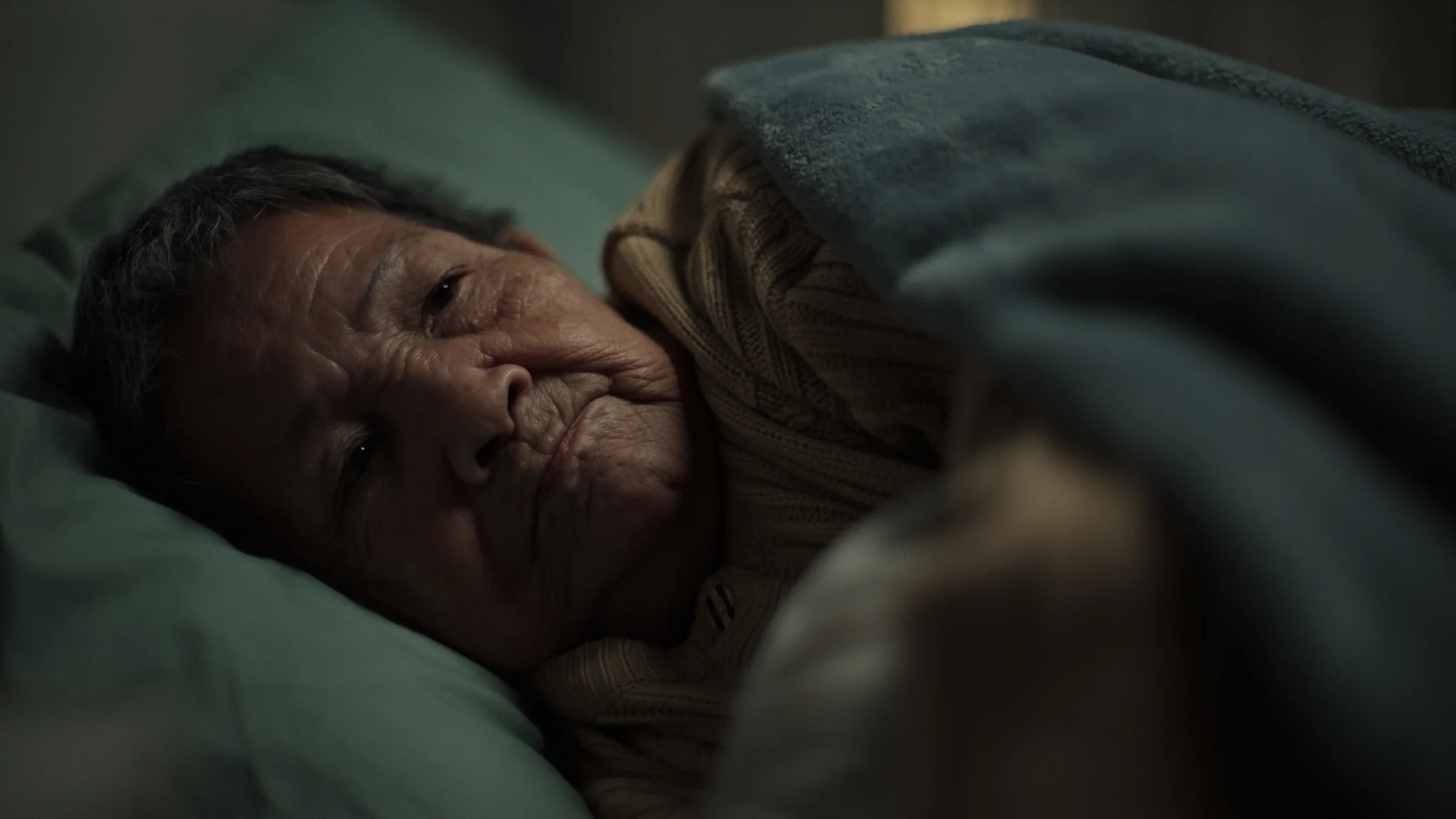 A woman experiences insomnia as she lies in bed with her eyes open.