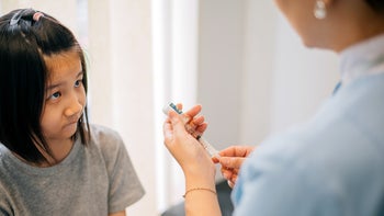 Covid 19: girl receiving vaccine 1472236223