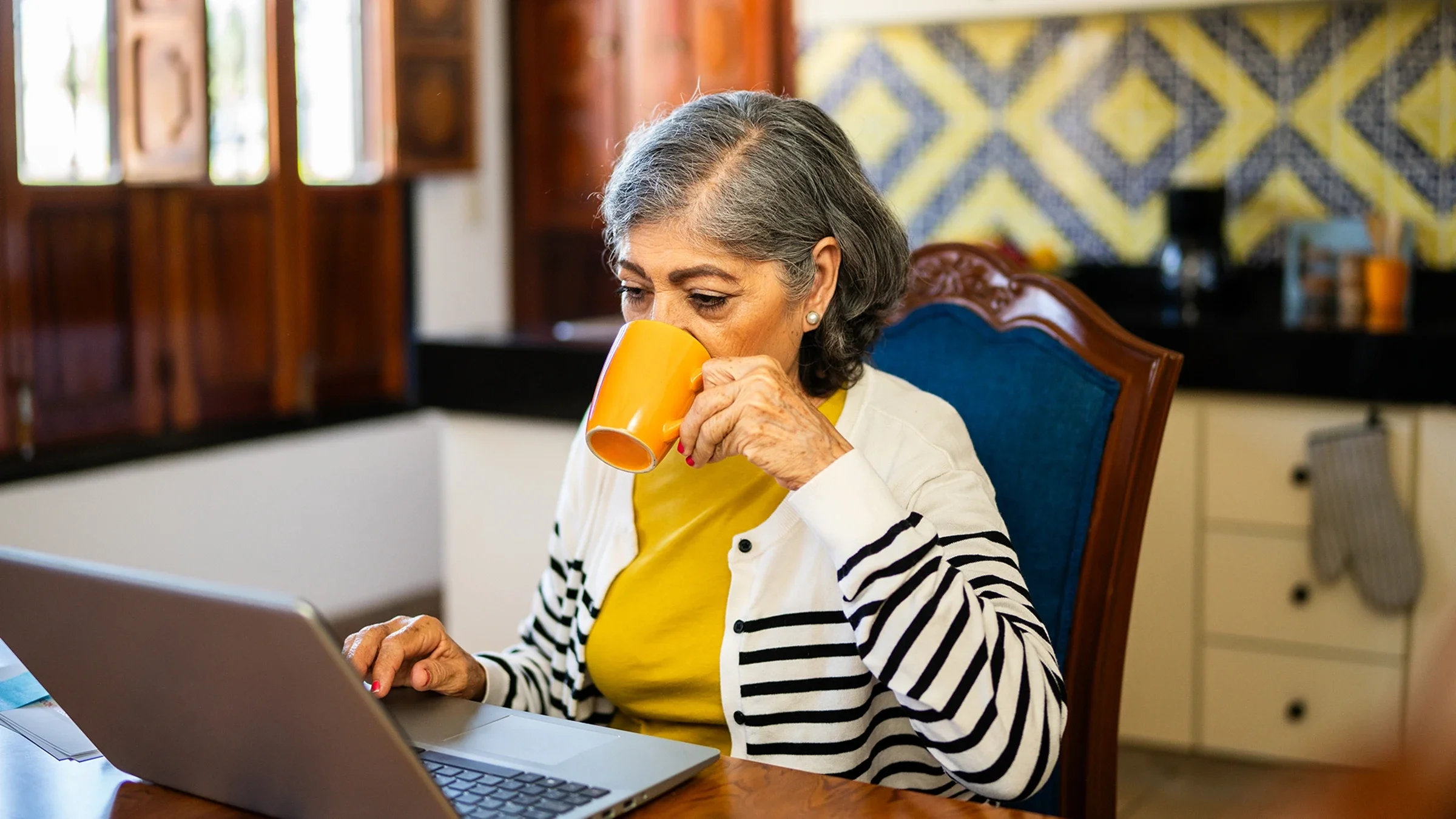 Woman working on a laptop with a cup of coffee