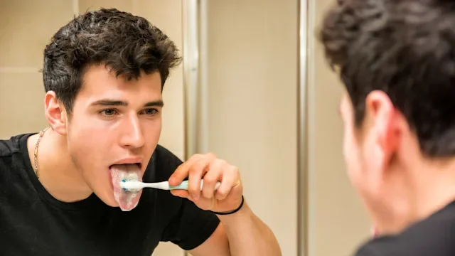 Dental care: brushing tongue in mirror 482932188