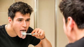 Dental care: brushing tongue in mirror 482932188