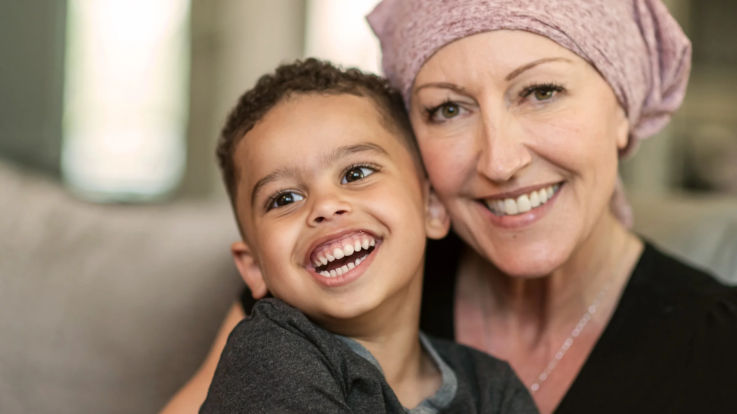 Portrait of a mother in a headscarf with her young son. They are smiling big!