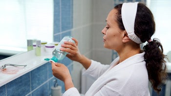 Dermatology: woman pours cleanser on cotton round 1419664867