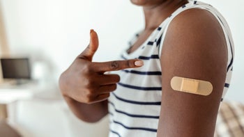 Medication Education: Side Effects: close up finger pointing to bandaid after vaccine-1383478163