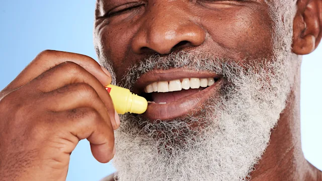Health-Insurance: closeup man using chapstick 1395676785