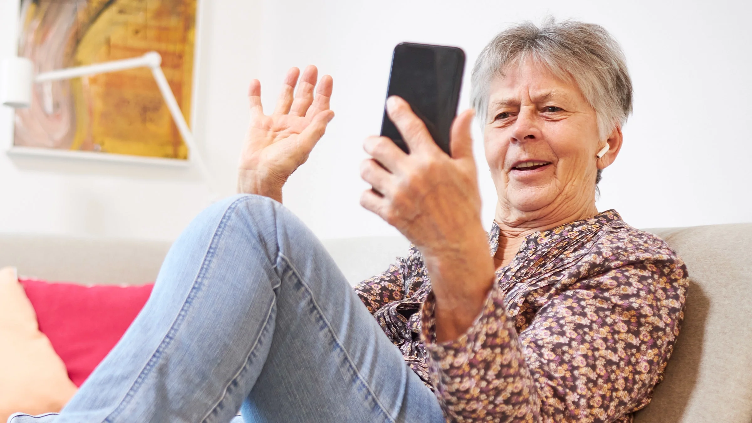 A person waving at their friend in a video call.