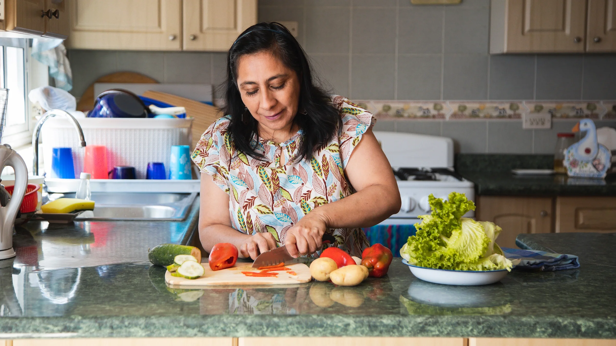 Woman slicing vegetables in the kitchen.
