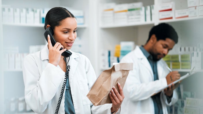 Pharmacist on telephone filling a prescription.